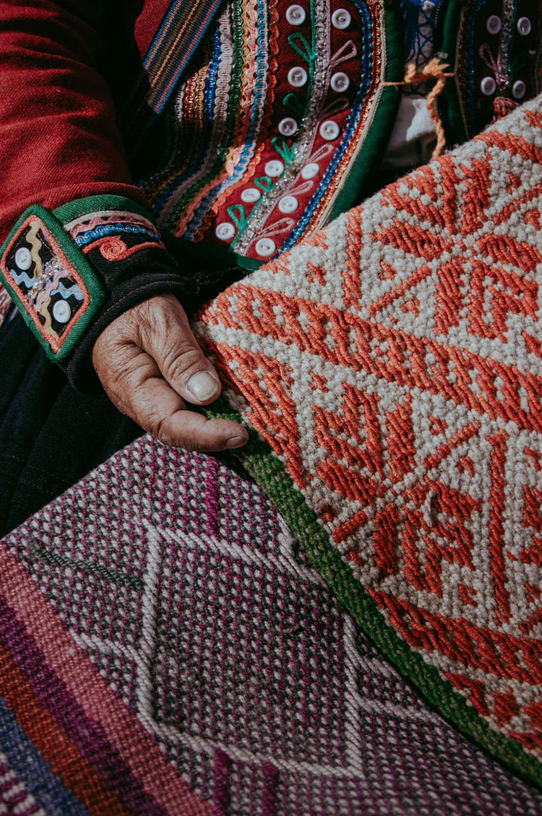 Andean weaver's hands holding a geometric woven textile