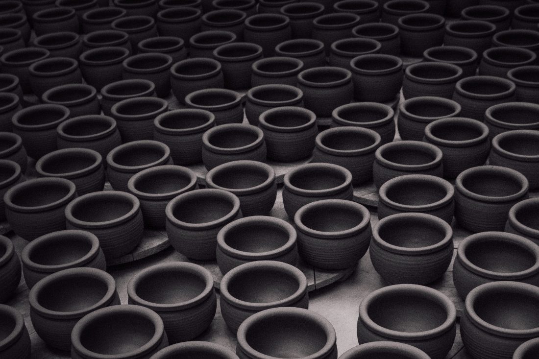Rows of unfired black clay pottery bowls